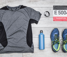 Camiseta, zapatillas, botella, reloj y dorsal para una maratón